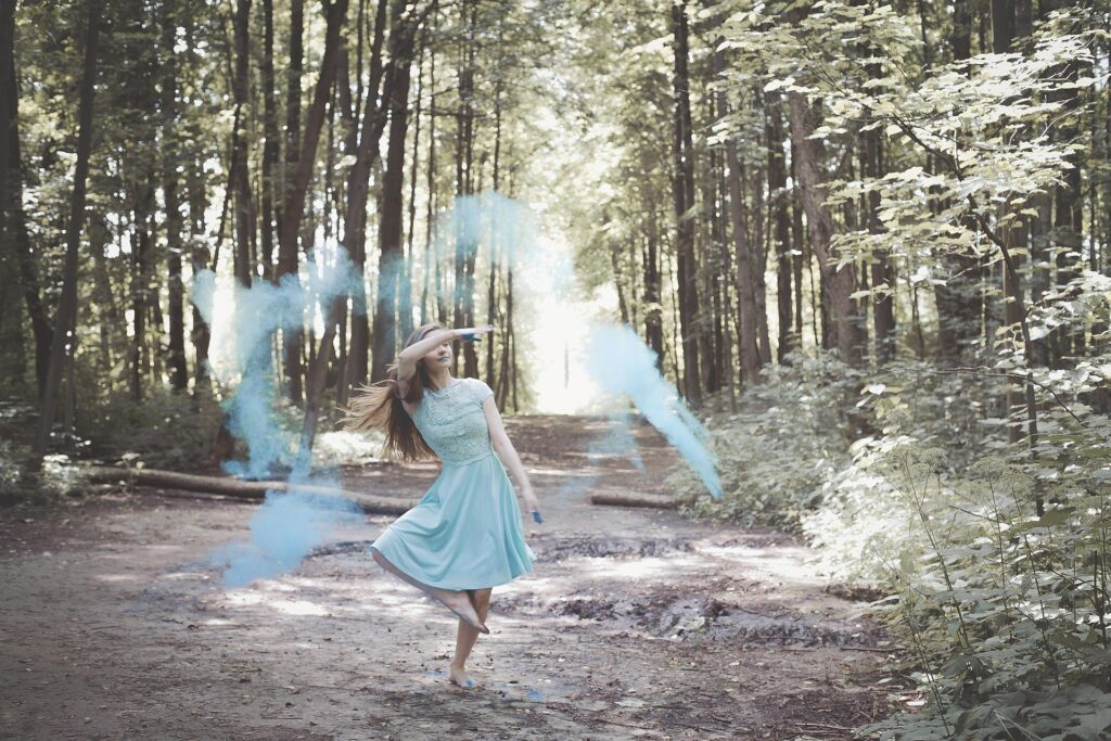 Woman walking or moving gently in soft forest light, symbolising renewal, grounding, and emotional reconnection.