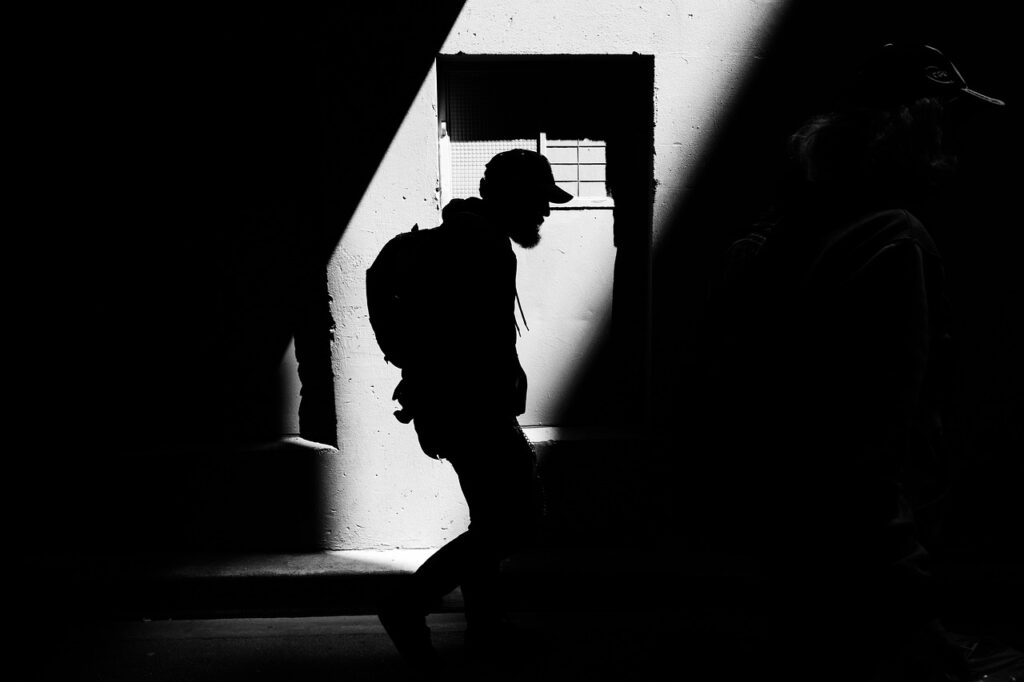 Silhouette of a person moving through shadow and light representing fear of visibility and self-expression